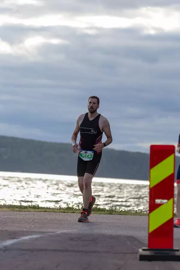 Marathon runner on the last meters of the Ironman competition in Finland 2019, with a lake Vesijärvi in the background