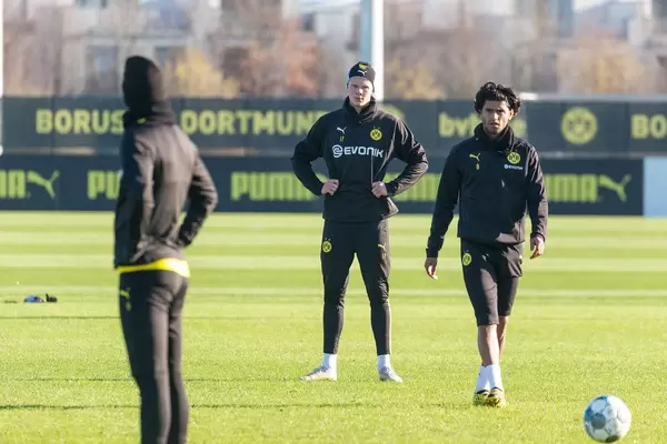Marco Reus and Erling Haaland watch Mahmoud Dahoud as he walks towards the ball during a Borussia Dortmund training