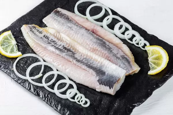 Marinated fish fillet with onion and lemon pieces