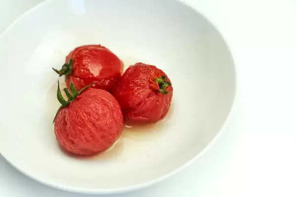 Marinated in vinegar pickled tomatoes on the plate. Refreshing cold appetizer