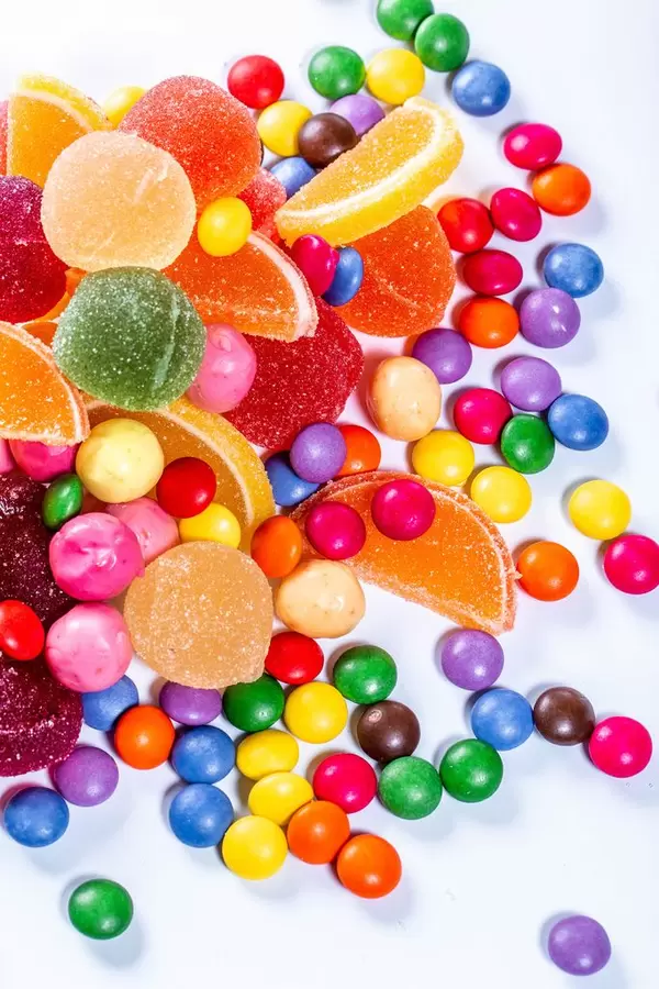 Marmelade elly und Pralinen von verschiedenen Farben auf weißem Hintergrund