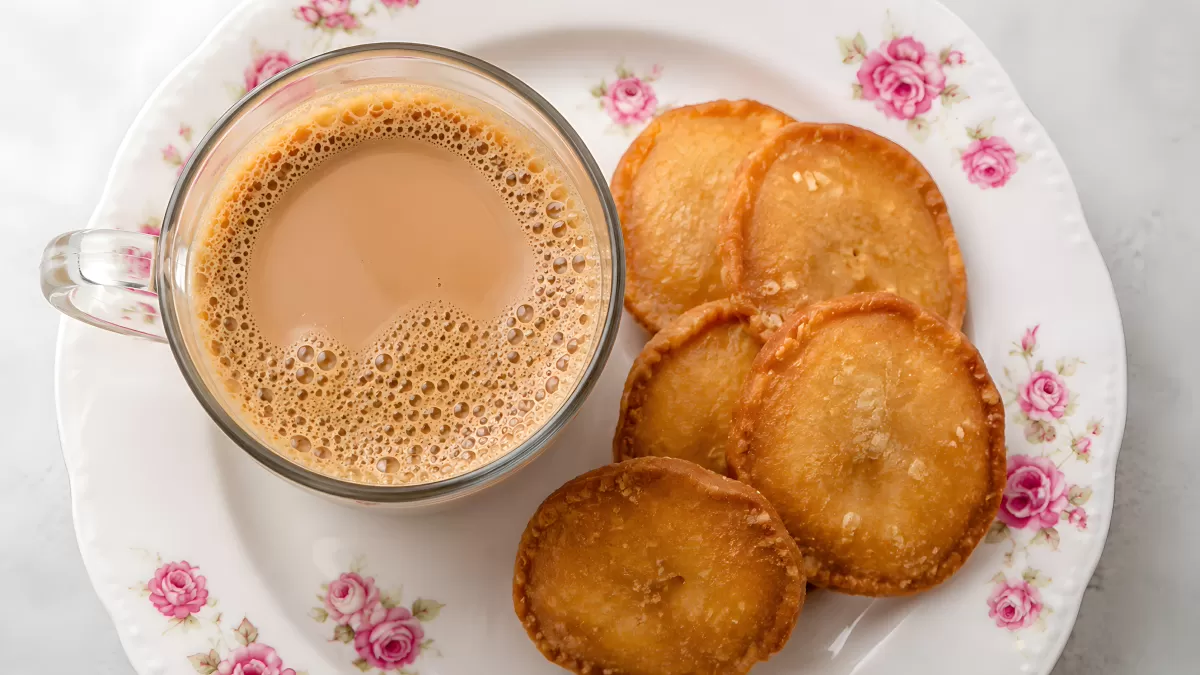 Masala Chai mit frittierten Teigfladen auf Rosenteller