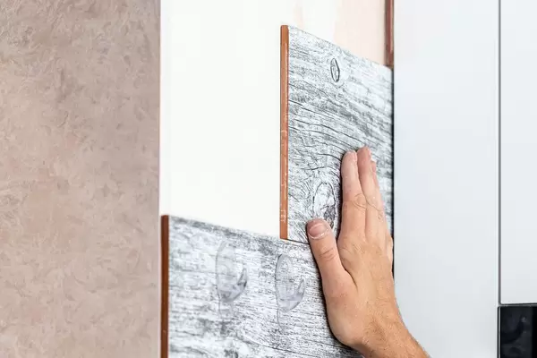Master puts ceramic tiles on the wall