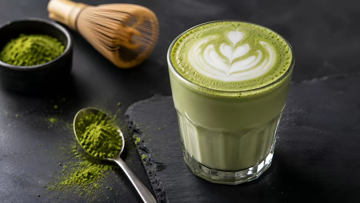 Matcha Latte im Glas mit Latte Art und Bambusquirl