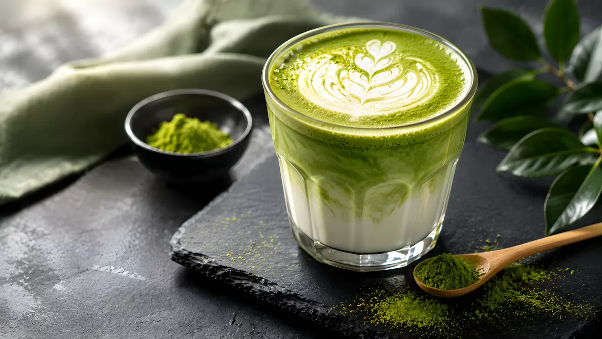 Matcha Latte mit Latte Art im Glas auf Schieferstein