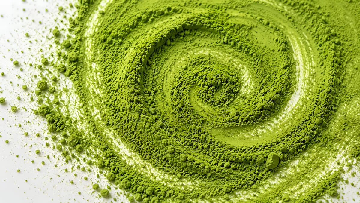 Matcha-Pulver in spiralförmigem Muster auf weißem Untergrund
