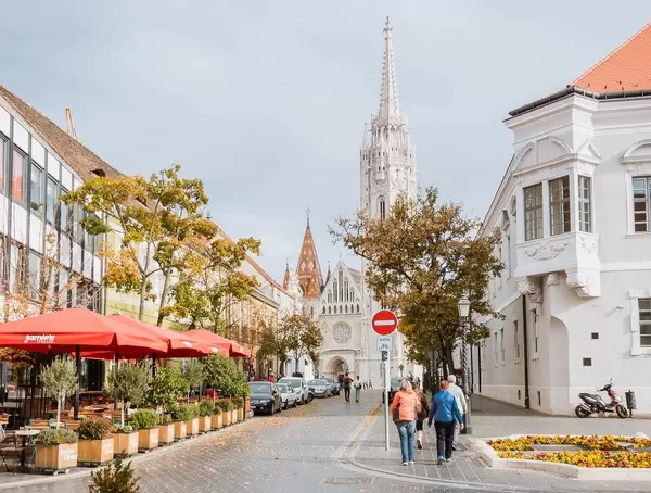 Matthiaskirche in Budapest mit einem Restaurant und spazierenden Touristen im Vordergrund
