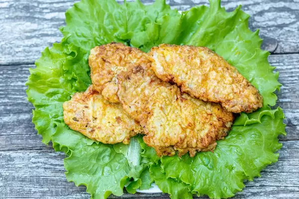 Meat chops fried in batter with lettuce leaves