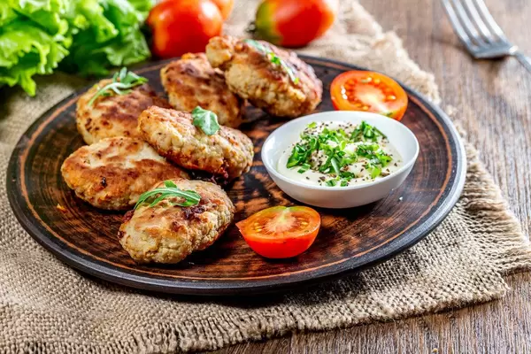 Meat cutlets with sauce and herbs in a brown plate on a burlap (Flip 2019)