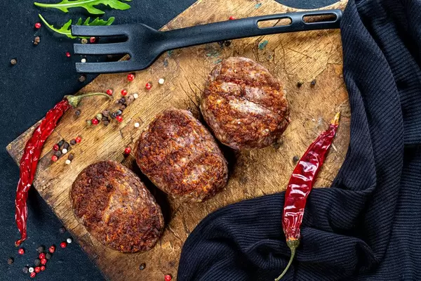 Meat cutlets with spices and chili on an old kitchen Board. Top view (Flip 2019)