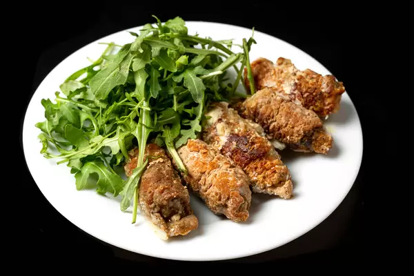 Meat rolls with fresh arugula leaves, close-up