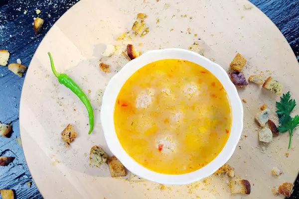 Meatball soup ith croutons and hot chili pepper