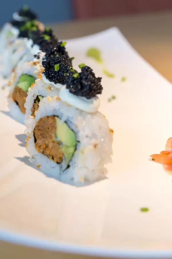 Meatless lunch for vegans, with Sushi "Lucky No Fish" filled with vegan tuna, vegan caviar substitute topping, spring onions, spicy sauce & avocado