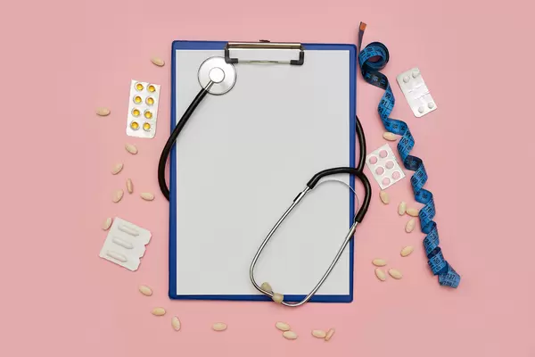 Medical background with stethoscope, medical pills and measuring tape