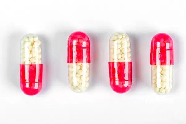 Medical capsules with medicine on white background, top view