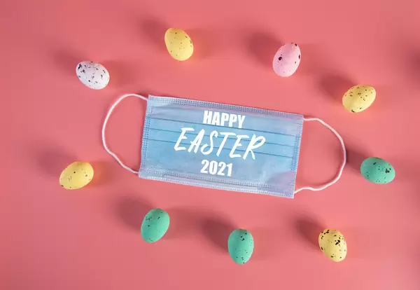 Medical face mask and colorful easter eggs with Happy Easter 2021 text
