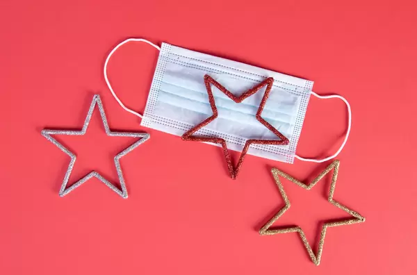 Medical face mask and stars on red background
