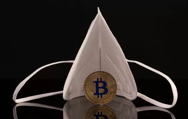 Medical face mask with golden Bitcoin coin on black background