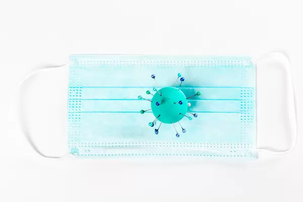 Medical mask for protection against flu and other viral diseases, with a model of a coronavirus bacterium made of plasticine