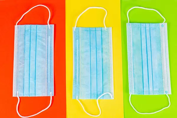 Medical masks on a red, yellow and green background