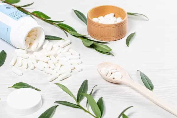 Medical preparations in capsules and tablets scattered on a white wooden background (Flip 2019)