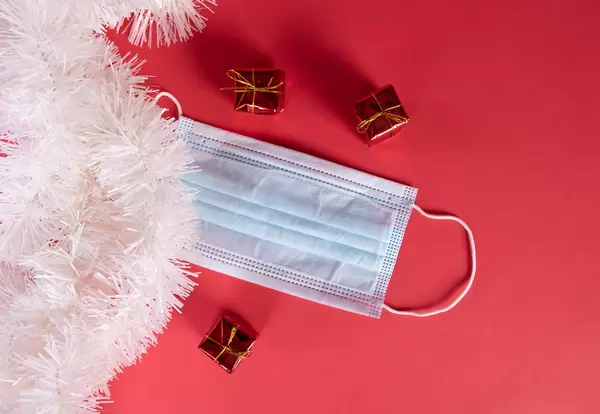 Medical protective mask and Christmas decorations on red blue background