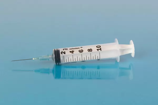 Medical syringe on blue background