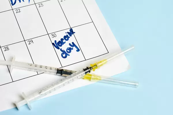 Medical syringes on calendar background