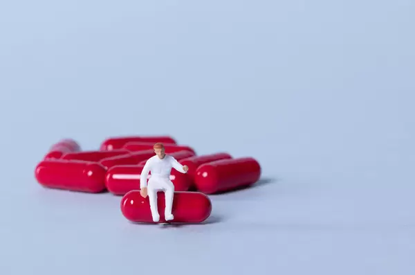 Medical worker sitting on a red pill