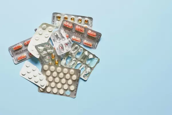 Medication and pills on light blue background