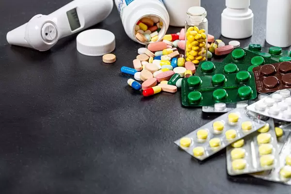 Medication, pills, thermometer, and cold spray on a black background (Flip 2019)