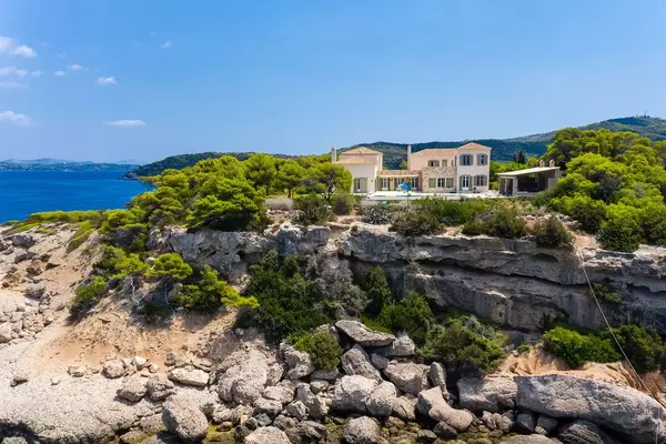 Mediterranean villa with pool surrounded by nature, on a rocky cliff of the Greek island Spetses