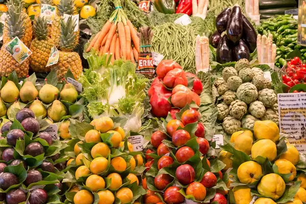 Mediterranes Obst & Gemüse wie Cherimoya, Spargel, Ananas, Fenchel und Auberginen in der Mercat de la Boqueria in Barcelona, Spanien