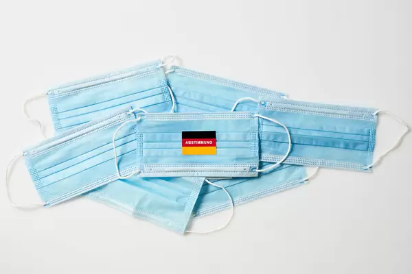 Medizinische Gesichtsmasken mit deutscher Flagge und Schrift "Abstimmung": Wahl in Corona-Zeit