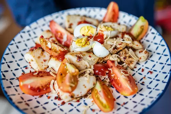 Meeresfrüchtesalat: Nahaufnahme von Tintenfischringen mit Tomaten