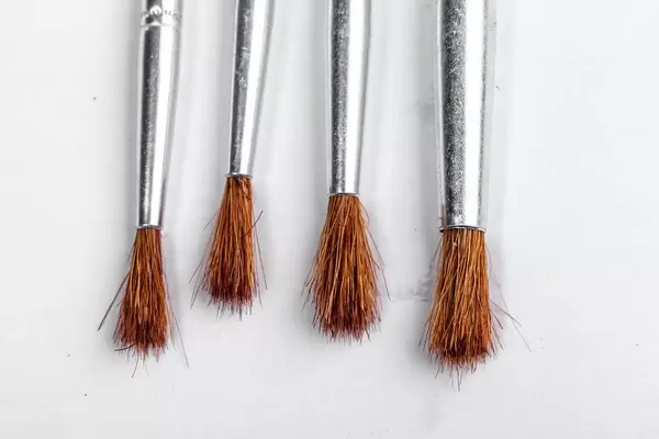 Mehrere Farbpinsel mit braunen Borsten auf weißem Hintergrund