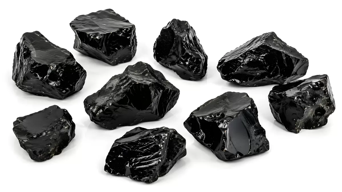 Mehrere glänzende schwarze Obsidiansteine auf weißem Grund