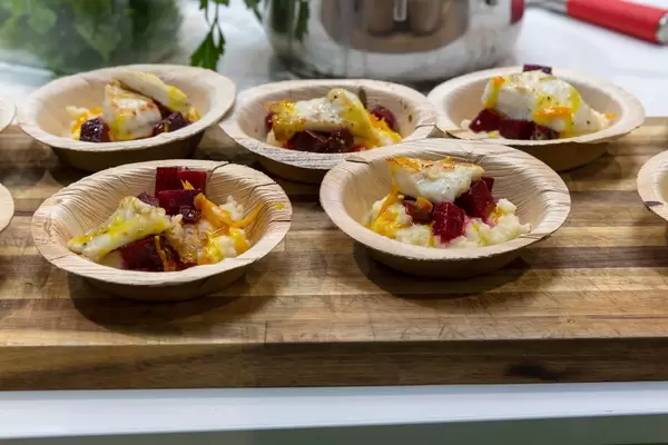 Mehrere Teller mit Fisch mit Gemüse und roter Bete als Ergebnis eines Showkochens