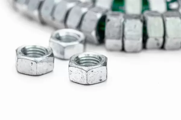 Mehrere Werkzeug-Muttern aus Eisen, auf weißem Hintergrund