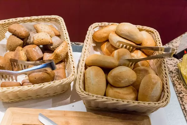 Mehrkornbrötchen und Baguette-Brötchen in Brotkörben