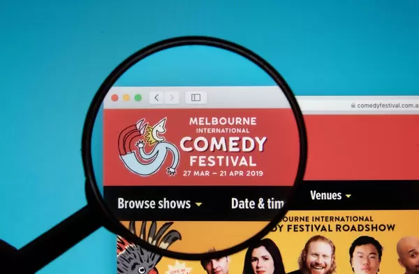 Melbourne International Comedy Festival logo on a computer screen with a magnifying glass