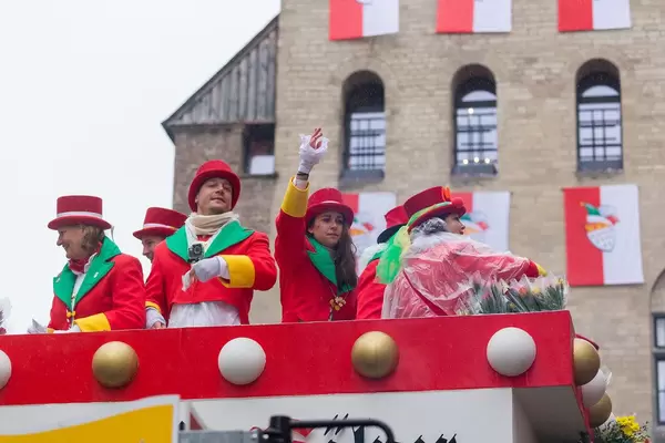 Members of the carnival society Große Kölner KG 1882 throw sweets and roses to the people watching the Rose Monday parade in Cologne