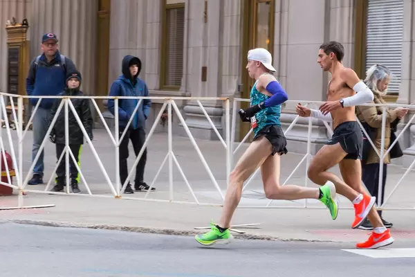 Men and male participants of Chicago marathon running shirtless through the streets