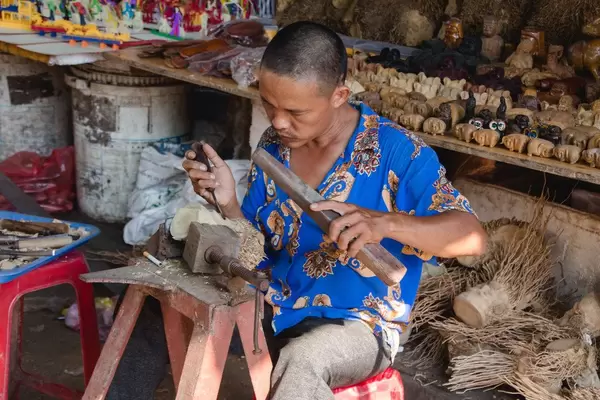 Men sculpting wood at the  Marke Vietnam. (Flip 2019)
