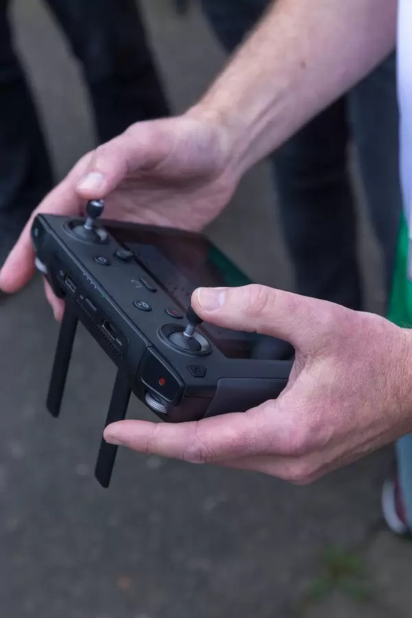 Men's hand holds the remote control DJI Mavic 2 Smart Controller with large display