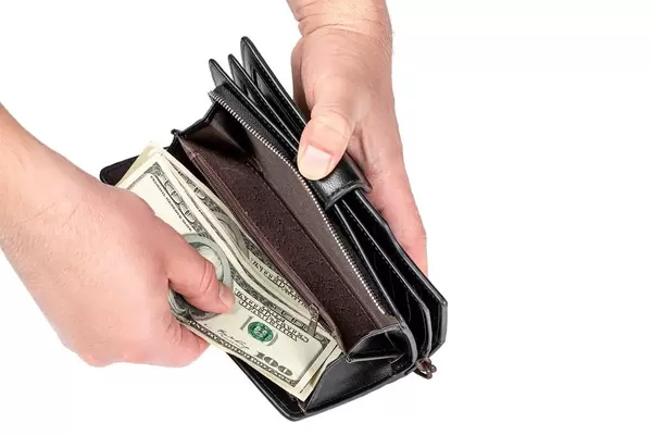 Men's hands put money in the wallet