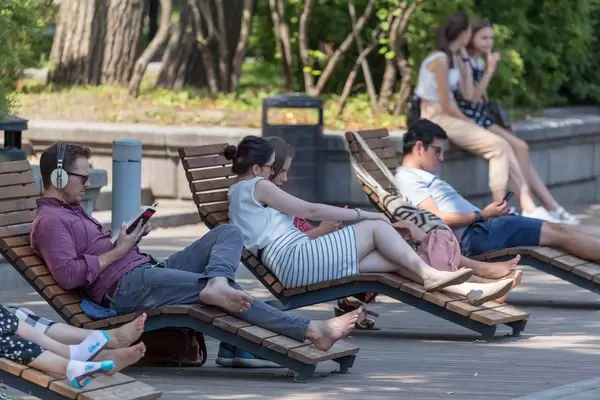 Menschen liegen auf Liegestühlen aus Holz