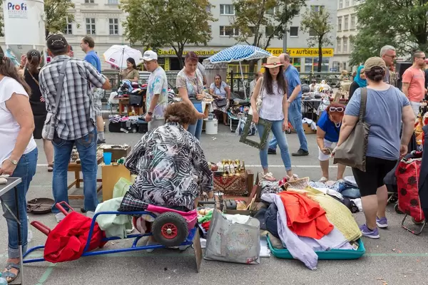 Menschen schauen sich gebrauchte Waren am Naschmarkt Flohmarkt an