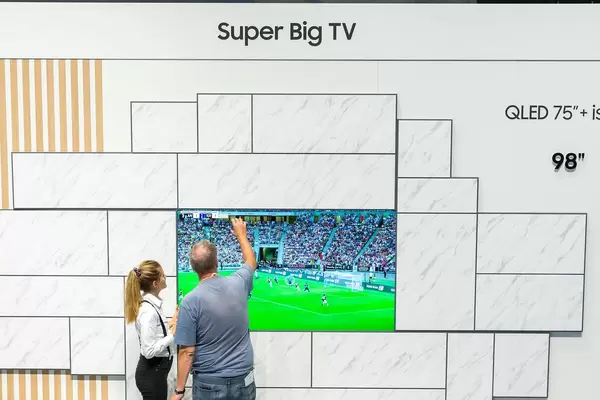 Menschen stehen vor dem Super Big TV QLED 75" von Samsung