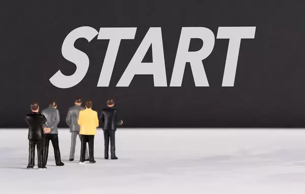 Menschen stehen vor dem Text "Start"